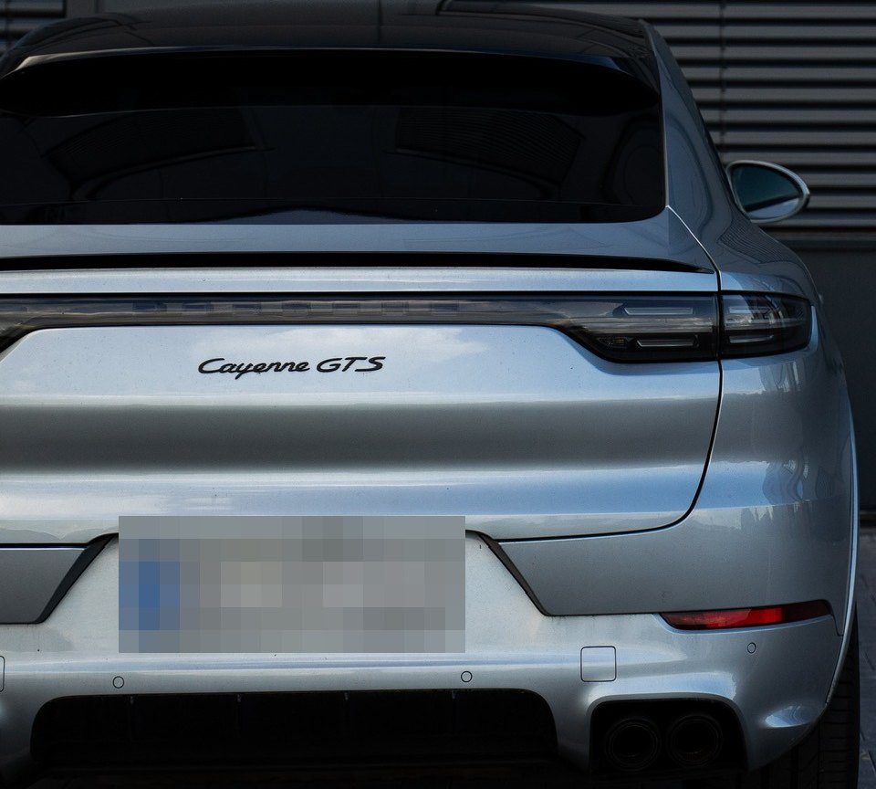 Silberner Porsche Cayenne GTS von hinten auf dem Hof von AutoHoss in Hemer